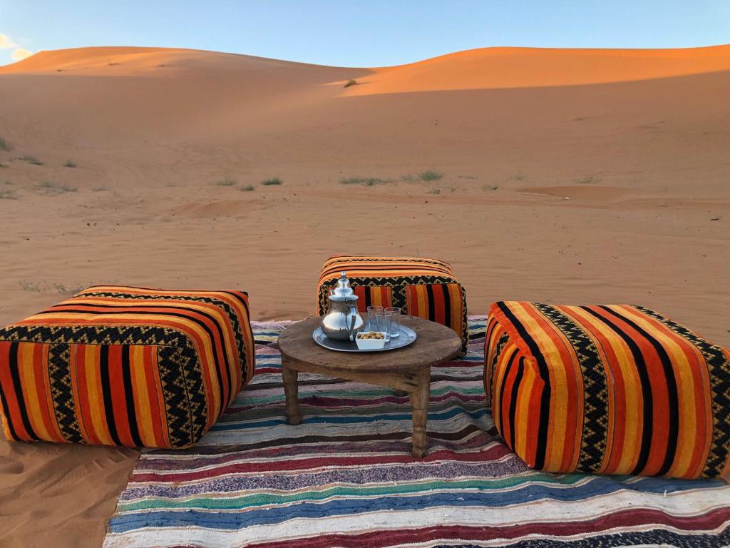 une table au milieu du désert dans l'établissement Bivouac Le Petit Prince Merzouga, à Merzouga