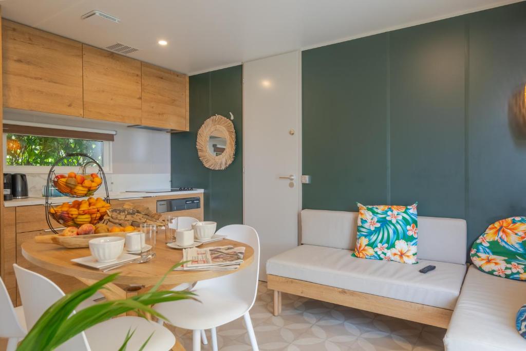a kitchen and dining room with a table and chairs at Camping Les Grenettes in Sainte-Marie-de-Ré