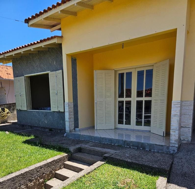 una casa con persiane bianche sul lato di House views of Imbituba Beach a Imbituba