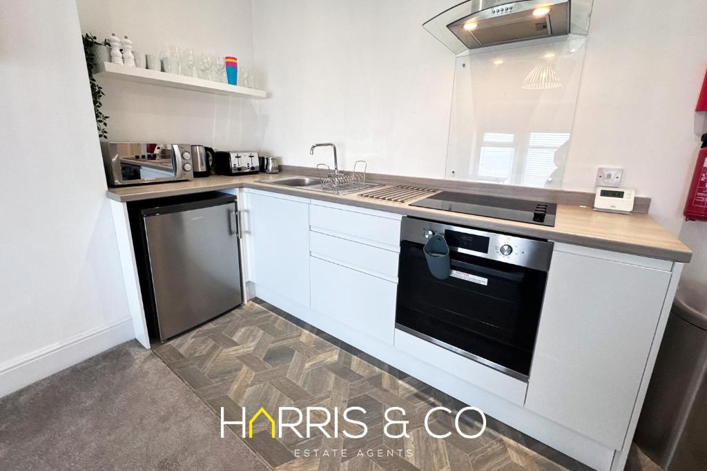 a kitchen with a black and white stove top oven at New Sandpiper Apartments in Fleetwood