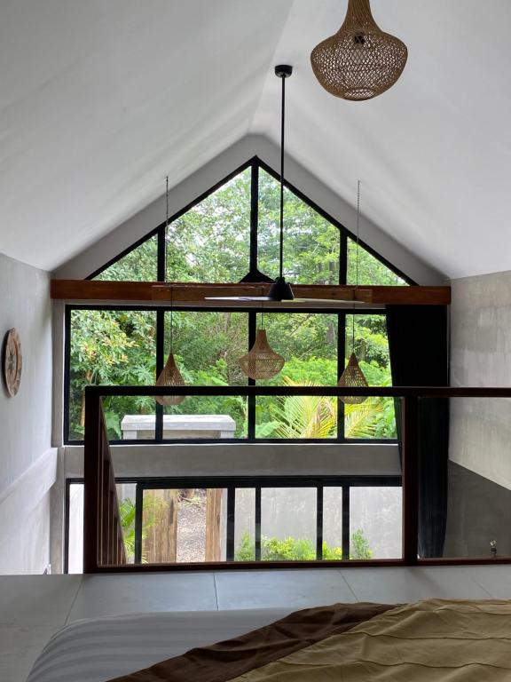 Habitación con ventana grande y mesa. en The Hike Uluwatu, en Uluwatu