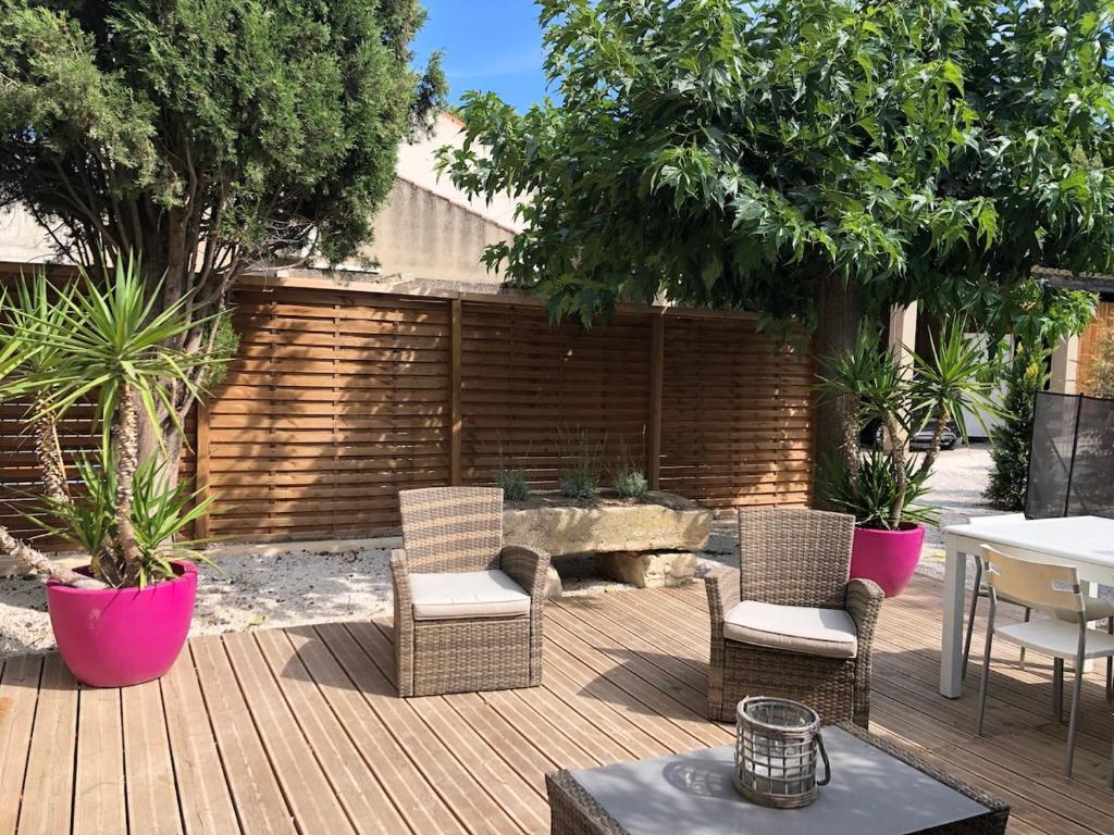 d'une terrasse avec des chaises en osier, une table et un sidx sidx sidx. dans l'établissement Maison au coeur du village, à Eyragues