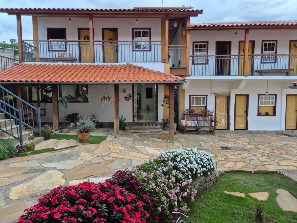 a large house with flowers in front of it at Pedacinho do céu in Tiradentes