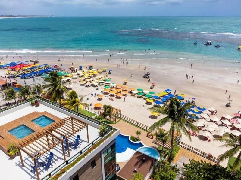 una playa con gente y sombrillas y el océano en Plage du Porto, en Porto de Galinhas