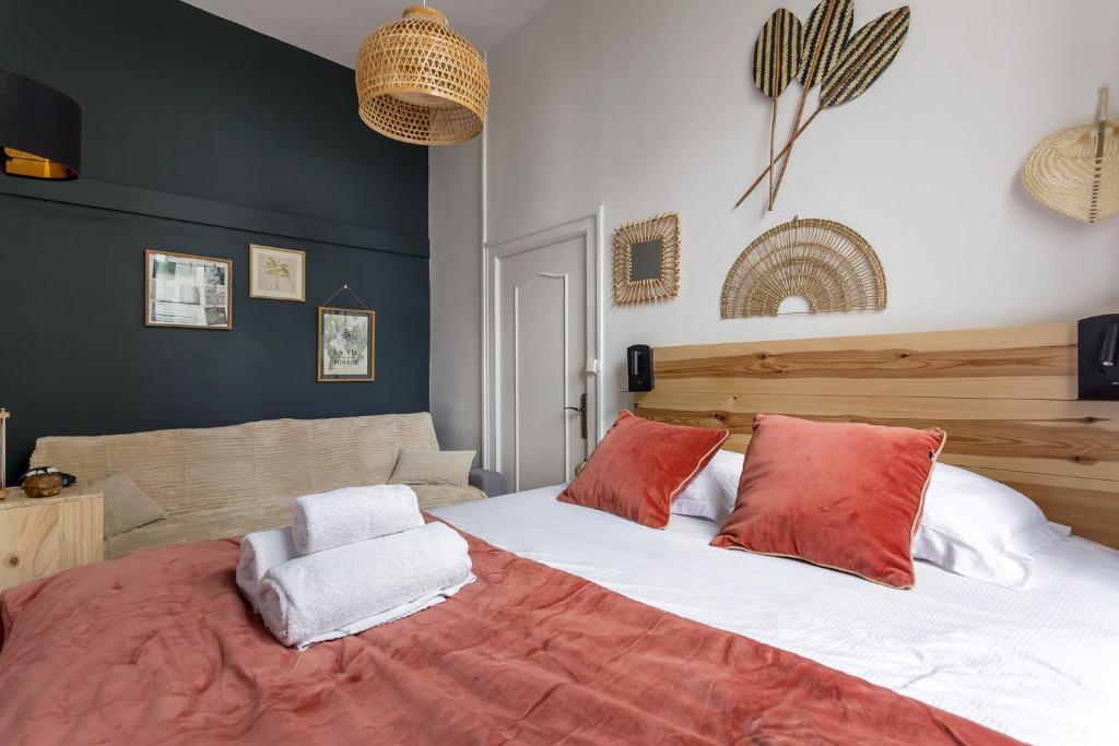 une chambre avec un grand lit avec des oreillers rouges et blancs dans l'établissement SmartStay Bon Pasteur- Croix rousse, à Lyon