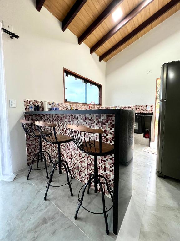 a bar in a room with a brick wall at Sossego e Boa Vista in Ilhabela