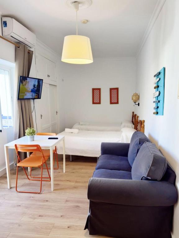 a living room with a couch and a table and a bed at El Jardin BeNerja in Nerja