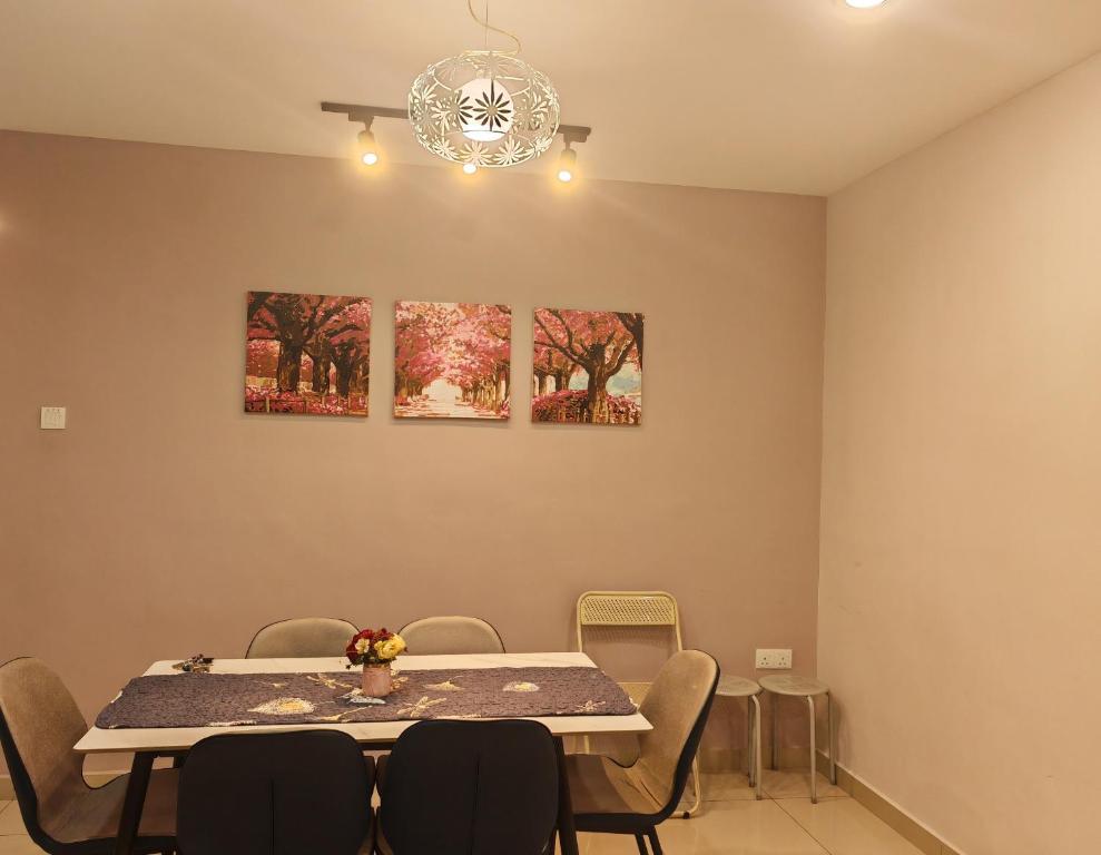 una mesa y sillas en una habitación con pinturas en la pared en Premium Manhattan Ipoh 怡保民宿, 4bedroom 12pax, water park, en Ipoh