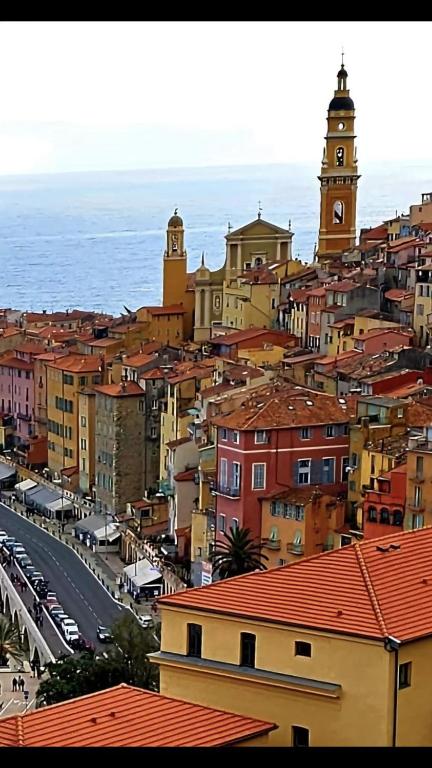 - une vue sur une ville avec une tour de l'horloge dans l'établissement Studio Menton proche de la gare et de la mer, à Menton