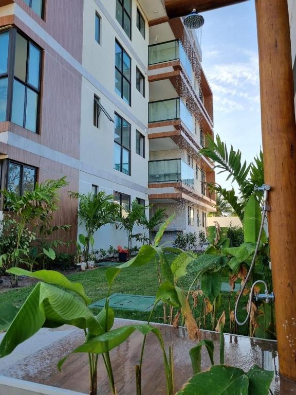 an apartment building with plants in front of it at Prédio em Barra Grande - Maragogi in Maragogi