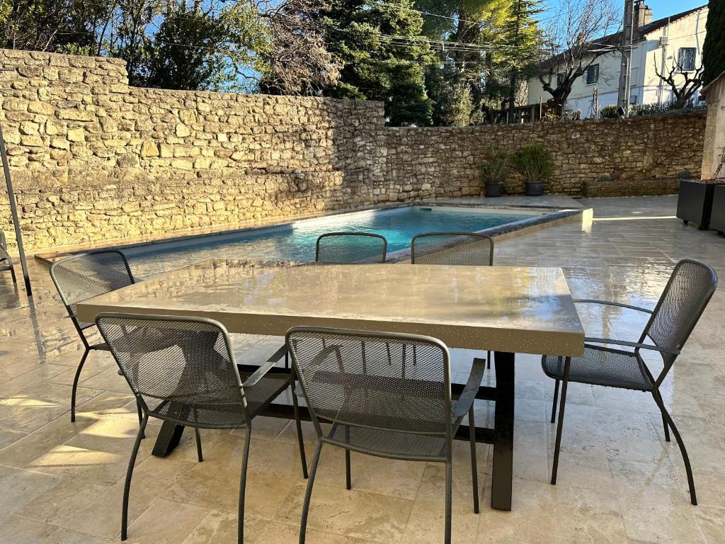 une table et des chaises devant une piscine dans l'établissement Appartement avec Piscine privée dans Résidence pour 6 personnes, à Uzès