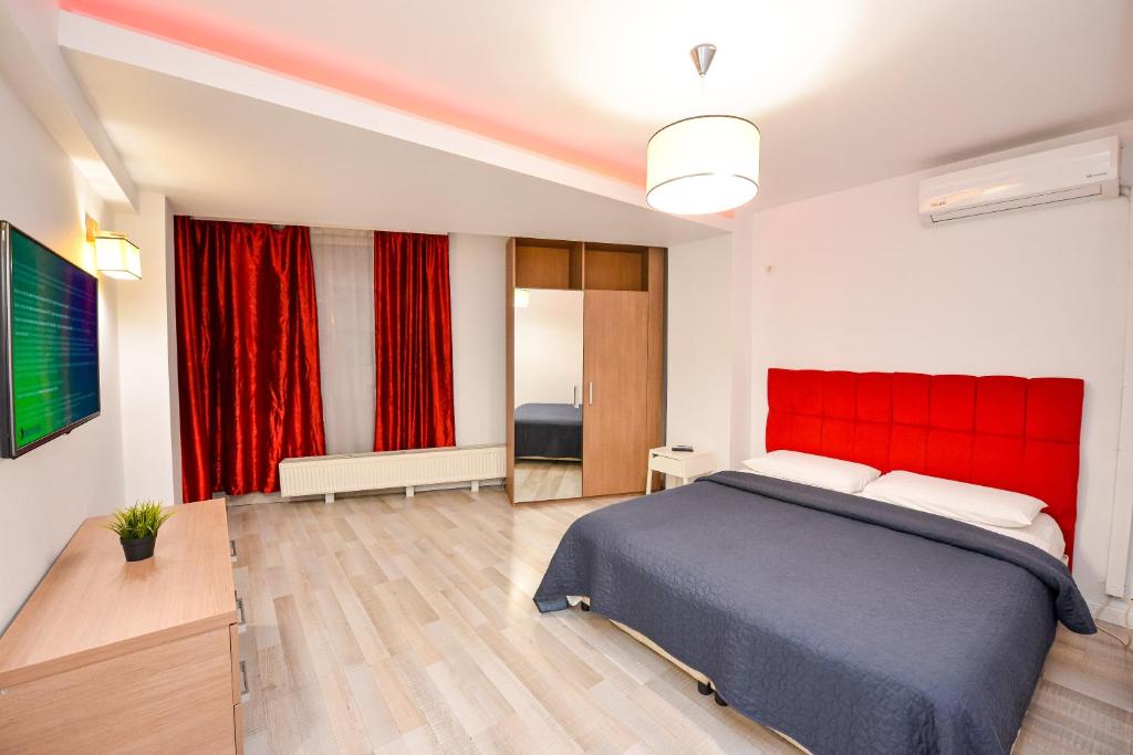 a bedroom with a large bed with a red headboard at Bucharest Accommodation Apartments in Bucharest