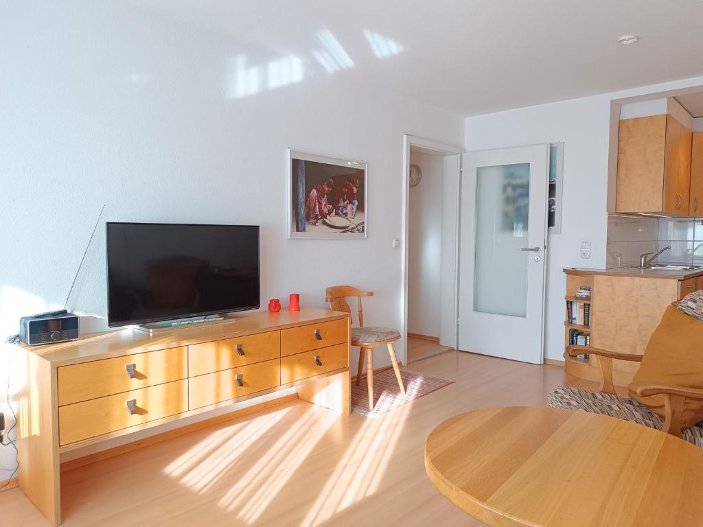 a living room with a television on a wooden dresser at 2-Raum FeWo Hüttenzauber - Hallenbad & Sauna in Fischen