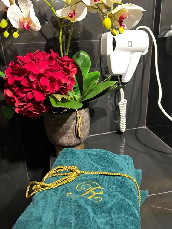 a vase of red flowers and a towel on a counter at B&B Bari Vecchia R in Bari