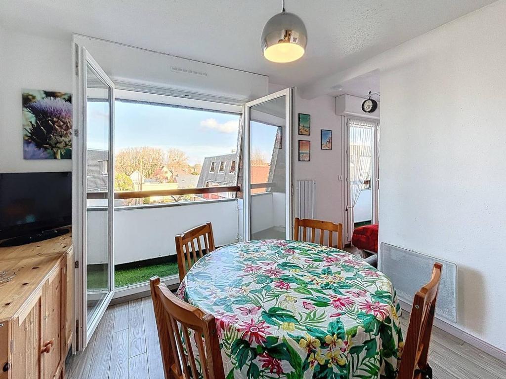 une salle à manger avec une table, des chaises et une télévision dans l'établissement Charmant Studio Cabine 4 Pers, Balcons, Parking Privé, à 300m de la Plage de Merville-Franceville - FR-1-465-37, à Merville-Franceville-Plage