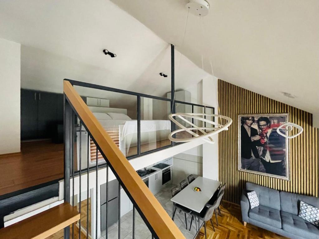 a loft bedroom with a bed and a staircase at City Gallery by Sienna in Skopje