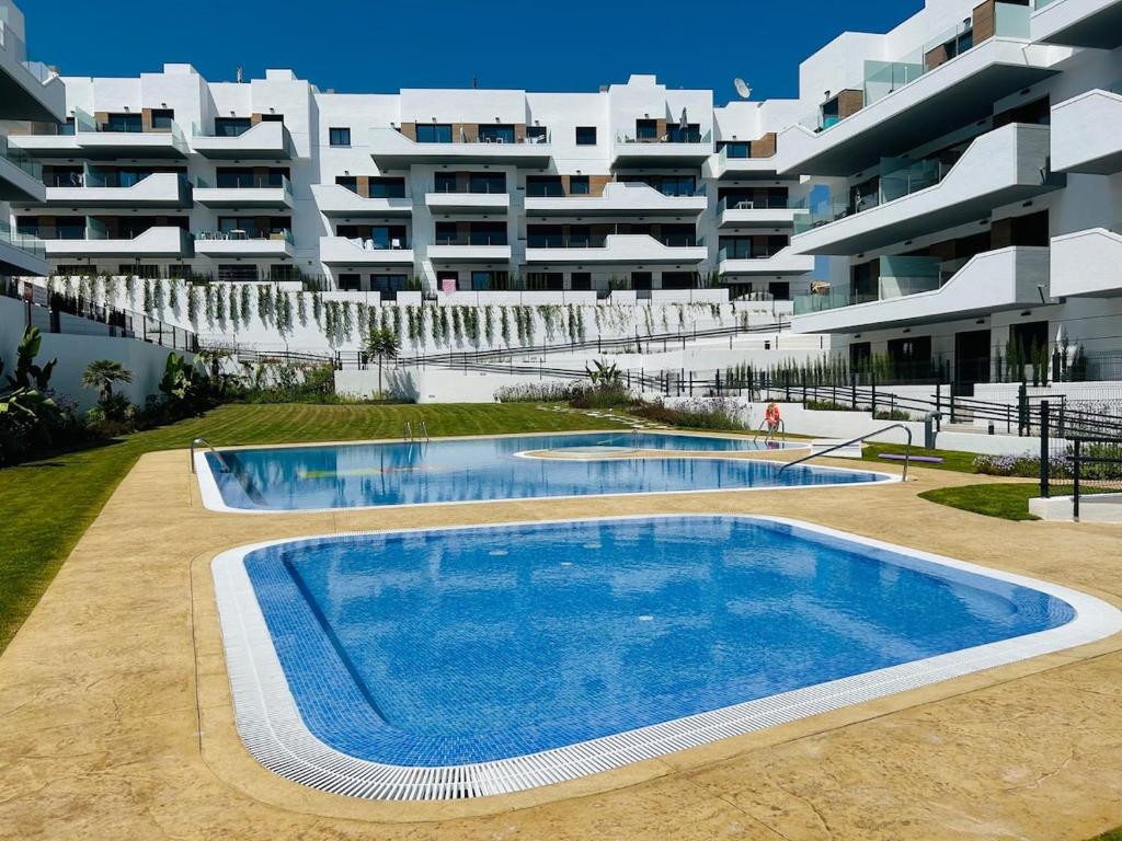 an empty swimming pool in front of a building at The white house in Villacosta