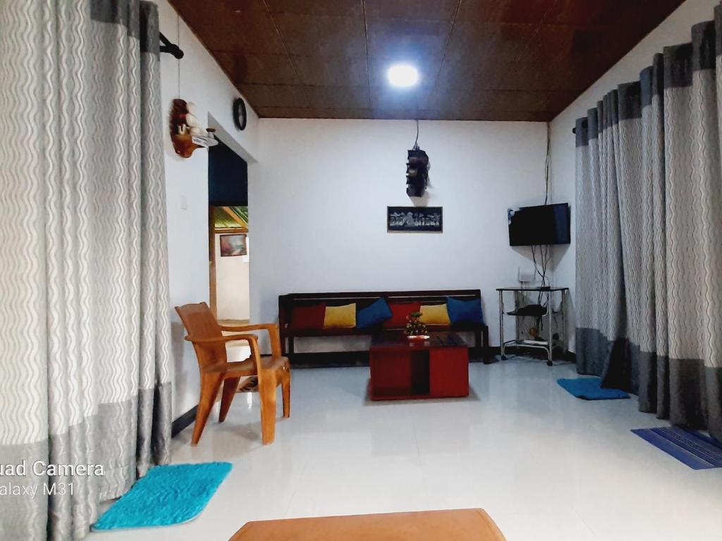 a living room with a bed and a chair at Dream Villa Homestay Madiha in Matara