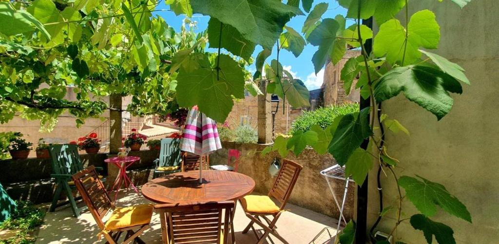 - une table et des chaises en bois sur une terrasse avec une table et des chaises dans l'établissement Appartement au coeur de Lavatoggio, à Lavatoggio