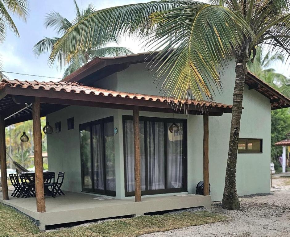 una pequeña casa con una palmera delante de ella en Pé de Serra Beach House - Serra Grande, en Serra Grande