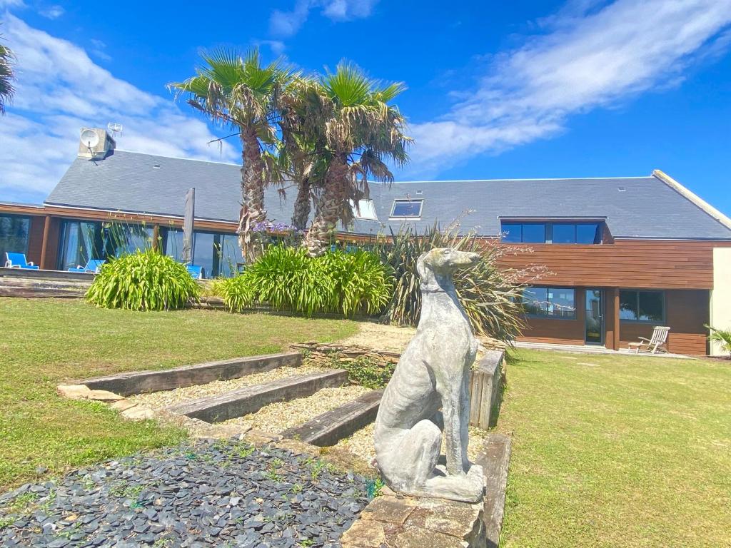 une statue d'un chien devant une maison dans l'établissement villa pointe du raz, à Plouhinec