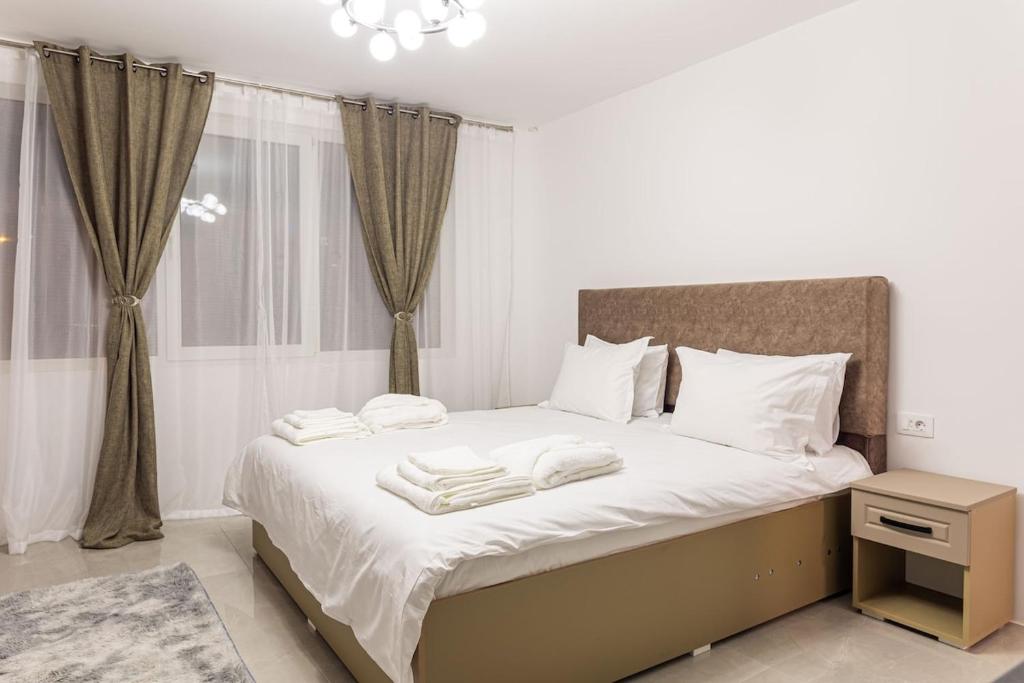 a bedroom with a bed with towels on it at Urban Retreat in Onești