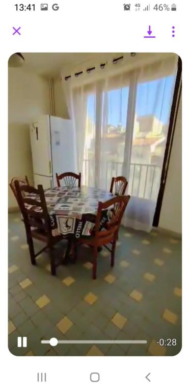 une table et des chaises dans une pièce avec une fenêtre dans l'établissement appartement lumineux sur le vieux port, à Marseille