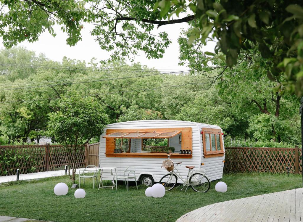 an rv parked in a yard with a bike at 不觉晓花园民宿 in Shanghai