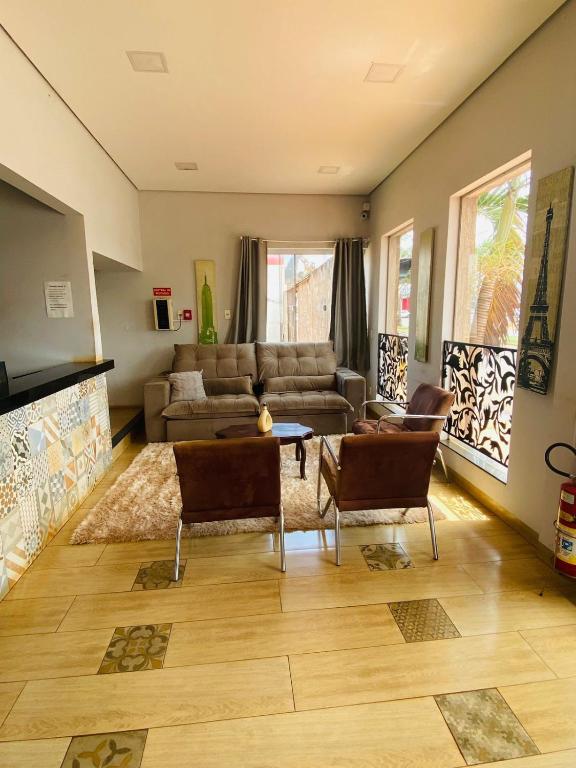 a living room with a couch and a table and chairs at Cerrado Gran Hotel in Rio Verde