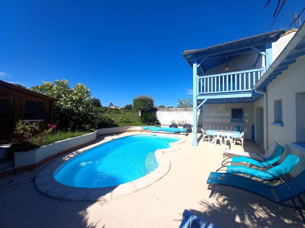 une piscine avec des chaises longues et une maison dans l'établissement Meschers sur Gironde - SEDUISANT COIN DE PARADIS avec sa PISCINE PRIVEE, à Meschers-sur-Gironde