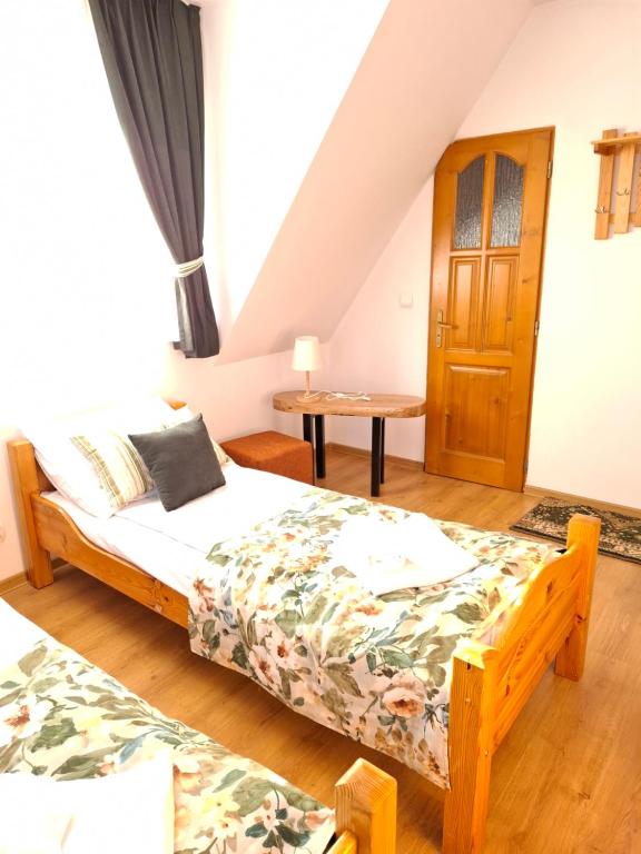 a bedroom with a bed and a table at Wynajem Pokoi - Halina i Wiesław Furczoń in Groń