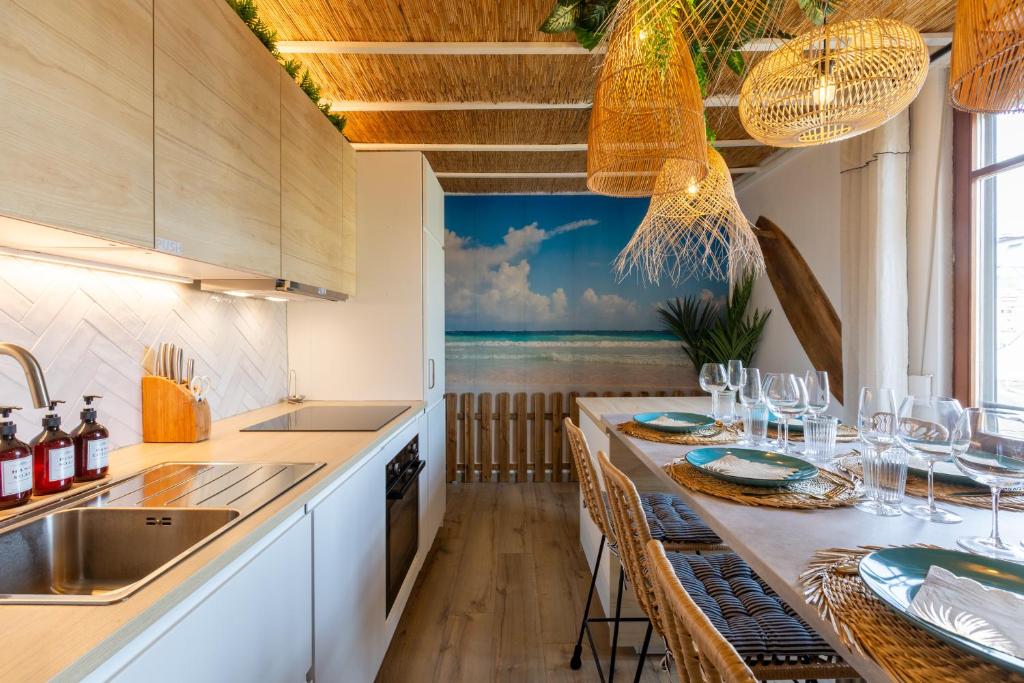 Una cocina con una mesa con sillas y un fregadero. en CathyVoyages - Ciel étoilé - Bord de Mer - Parking gratuit - Vidéoprojecteur - Lit rond - La Paillote Strasbourgeoise, en Estrasburgo