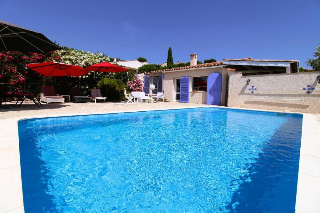 une grande piscine bleue devant une maison dans l'établissement Villa Les Lauriers Blancs pour 6 personnes avec piscine privée et vue mer à La Londe-Les-Maures, à La Londe-les-Maures