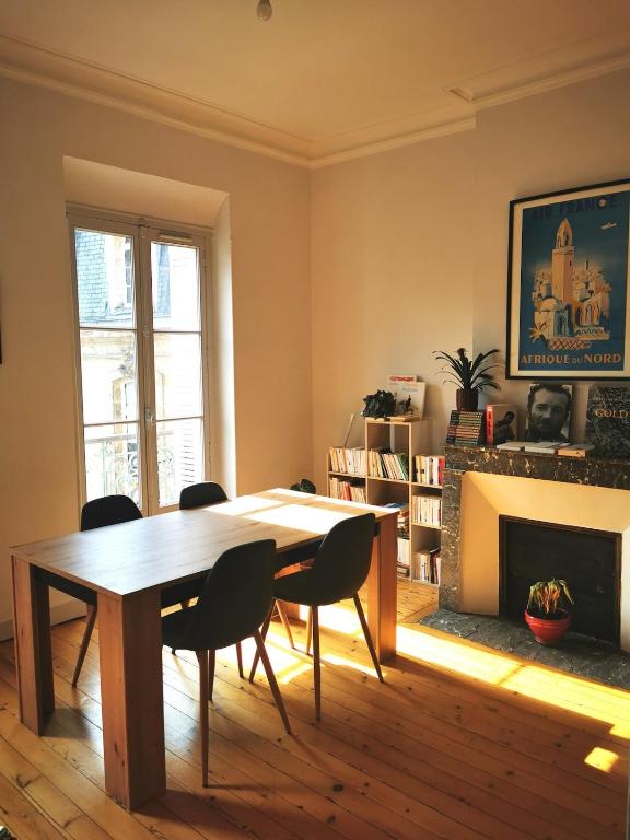 une salle à manger avec une table et des chaises et une cheminée dans l'établissement Bordeaux hypercenter apartment, à Bordeaux