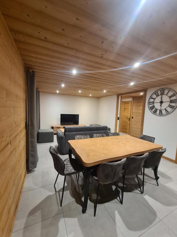une salle de conférence avec une table, des chaises et une horloge dans l'établissement loulettaz 2, au Grand-Bornand