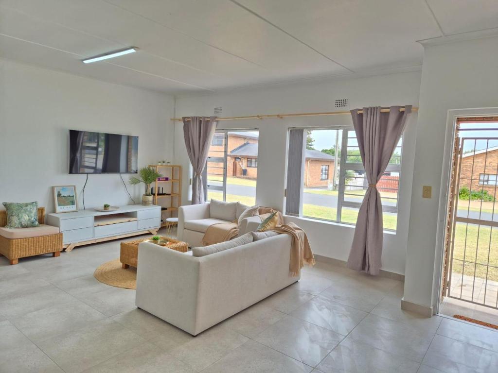 a living room with a couch and a tv at Hello Home Struisbaai in Struisbaai