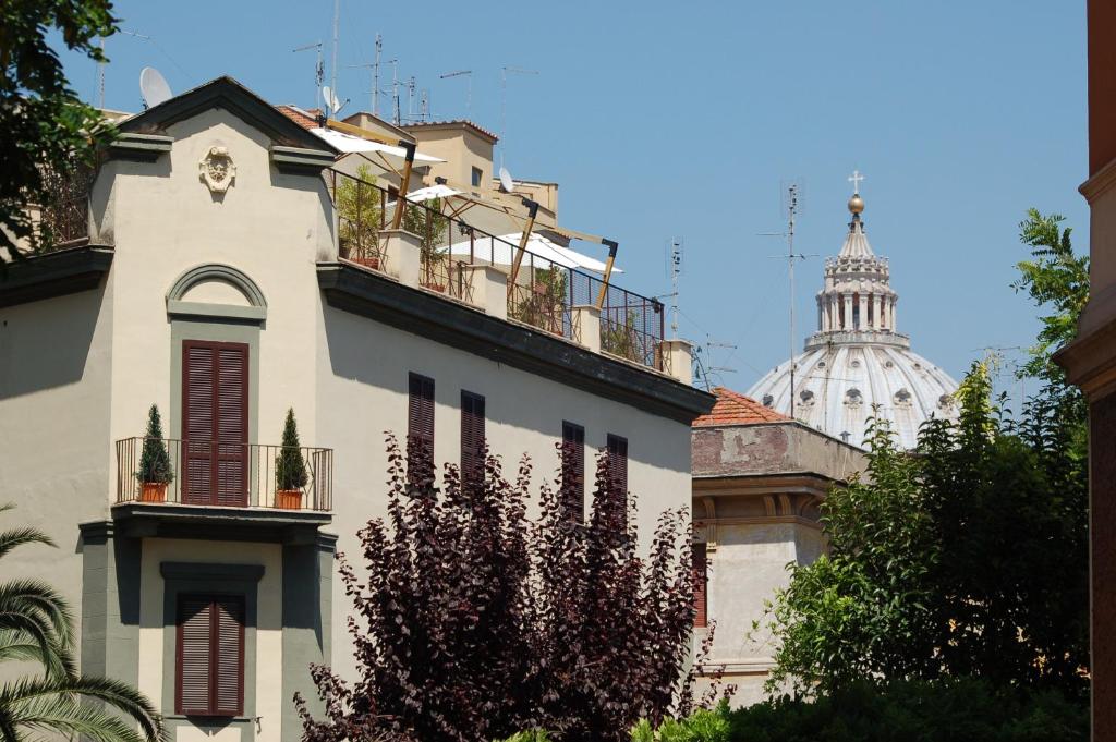 Edificio blanco con balcón y torre en Hotel Residence Vatican Suites, en Roma
