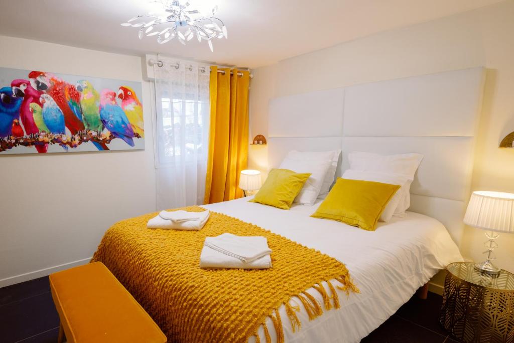 a bedroom with a bed with yellow sheets and yellow pillows at Sunny Suite by Leslodgespa - Studio moderne et coloré, proche de Bâle et de l'aéroport in Blotzheim