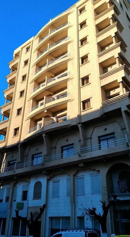 un edificio de apartamentos alto con balcones en un lateral en MAJESTIC Hotel Annaba, en Annaba