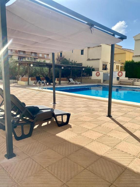 a patio with a white canopy and a swimming pool at Global Sun - Casa Pasco in Playa de Gandia