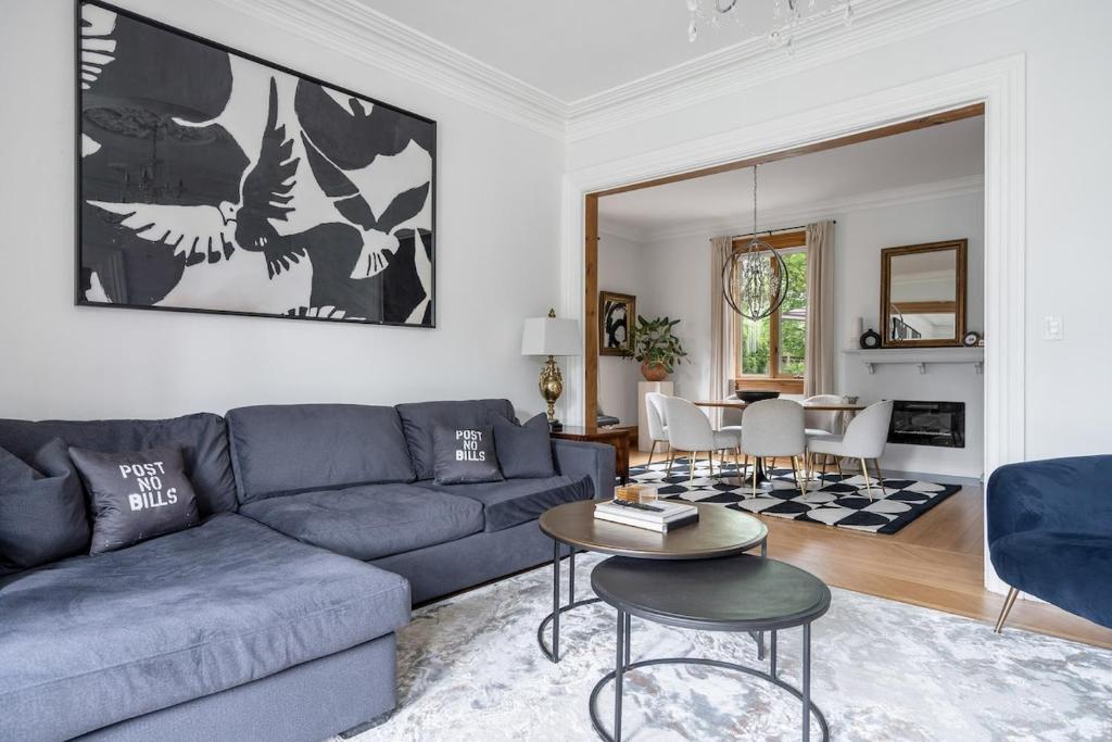 a living room with a blue couch and a table at 3bed 2bath heritage duplex - Prime Location in Collingwood