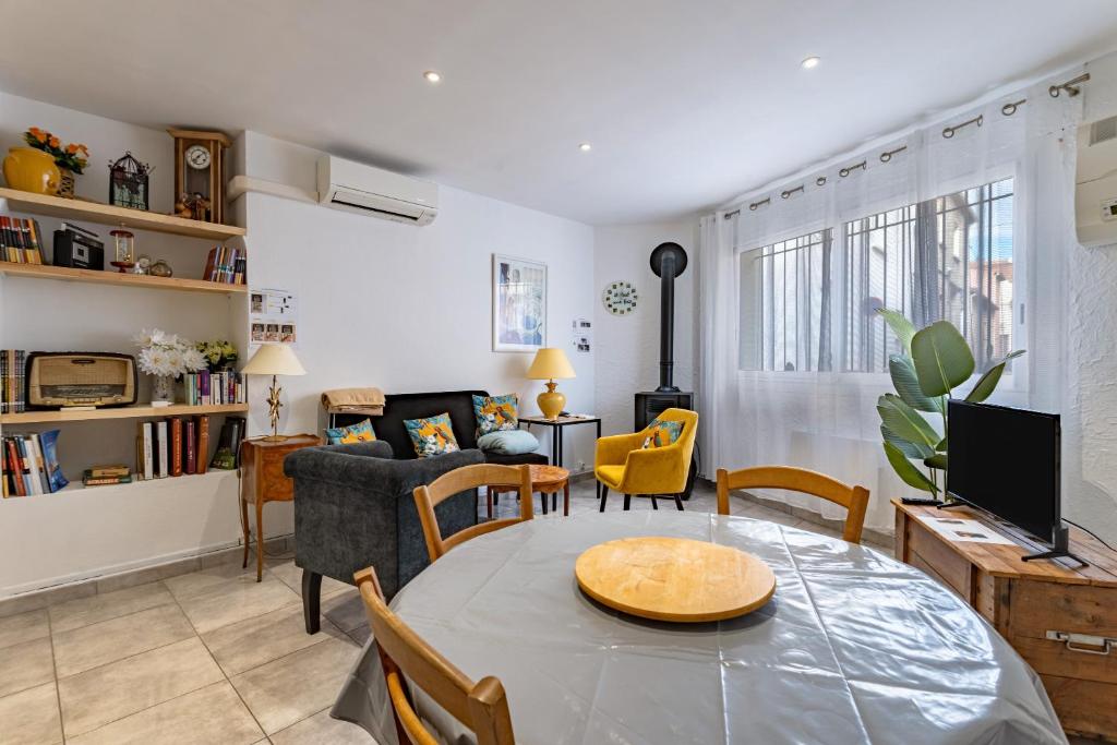 a living room with a table and a couch at L'Oreneta, Le Boulou, idéal curiste in Le Boulou