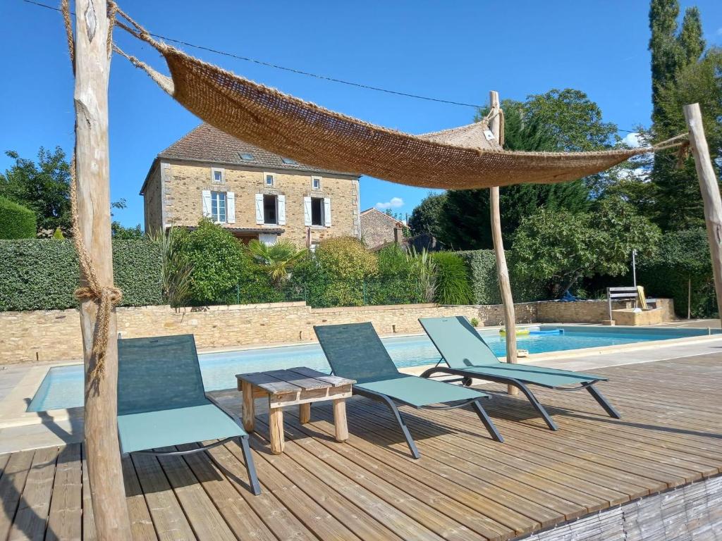 un'amaca e delle sedie su un ponte accanto a una piscina di Gîtes de Charme Lalaurie a Sauveterre-la-Lémance