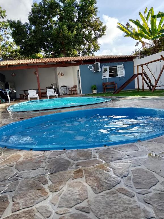 a large swimming pool with blue water in a yard at Casa Portal do Sol JP in João Pessoa