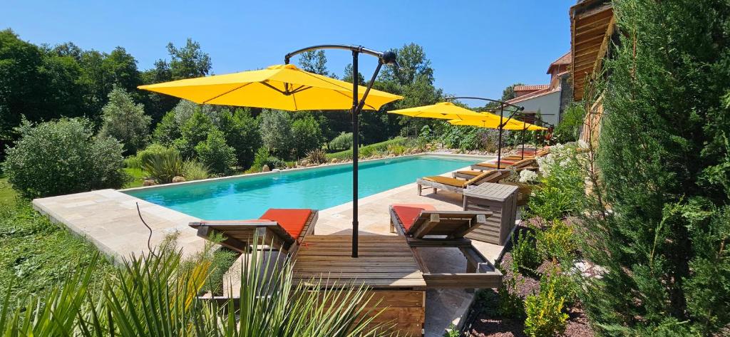 - une piscine avec des chaises et des parasols à côté d'une maison dans l'établissement Château la bastide cardan, à Saint-Sulpice-de-Pommiers