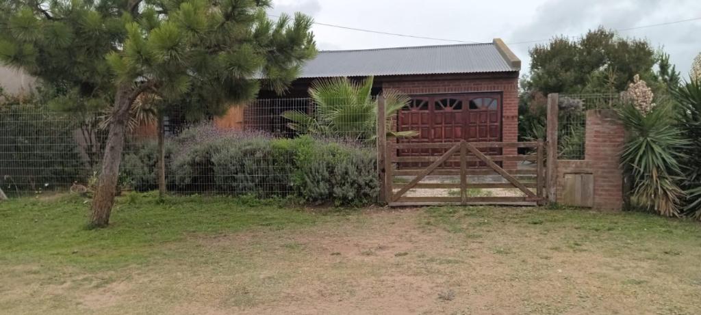 a barn with a wooden gate and a fence at Casa quinta vacacional in Mar del Tuyú