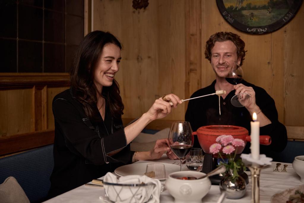 a man and woman sitting at a table with a glass of wine at TOP Hotel Hochgurgl in Hochgurgl