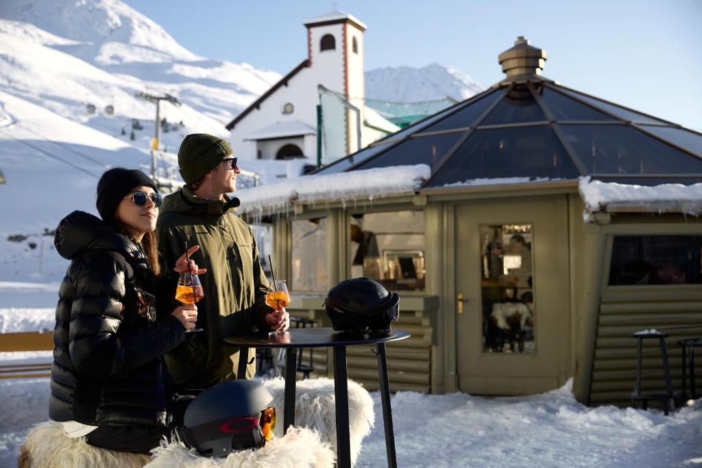 a man and a woman sitting at a table in the snow at TOP Hotel Hochgurgl in Hochgurgl