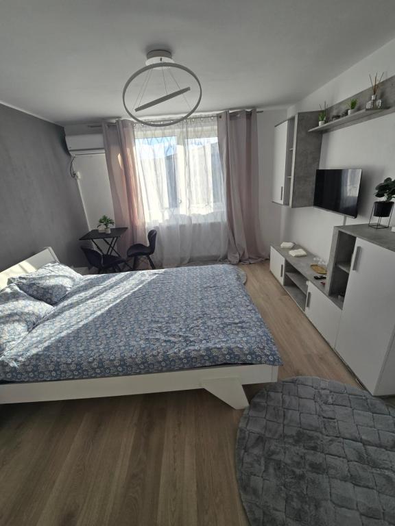 Un dormitorio con una cama con un edredón azul. en Garsoniera - moderna - Timișoara, en Timisoara