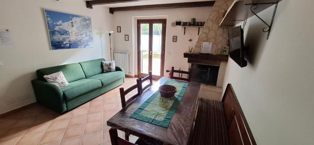 salon z zieloną kanapą i stołem w obiekcie Garden House Alfedena w mieście Alfedena